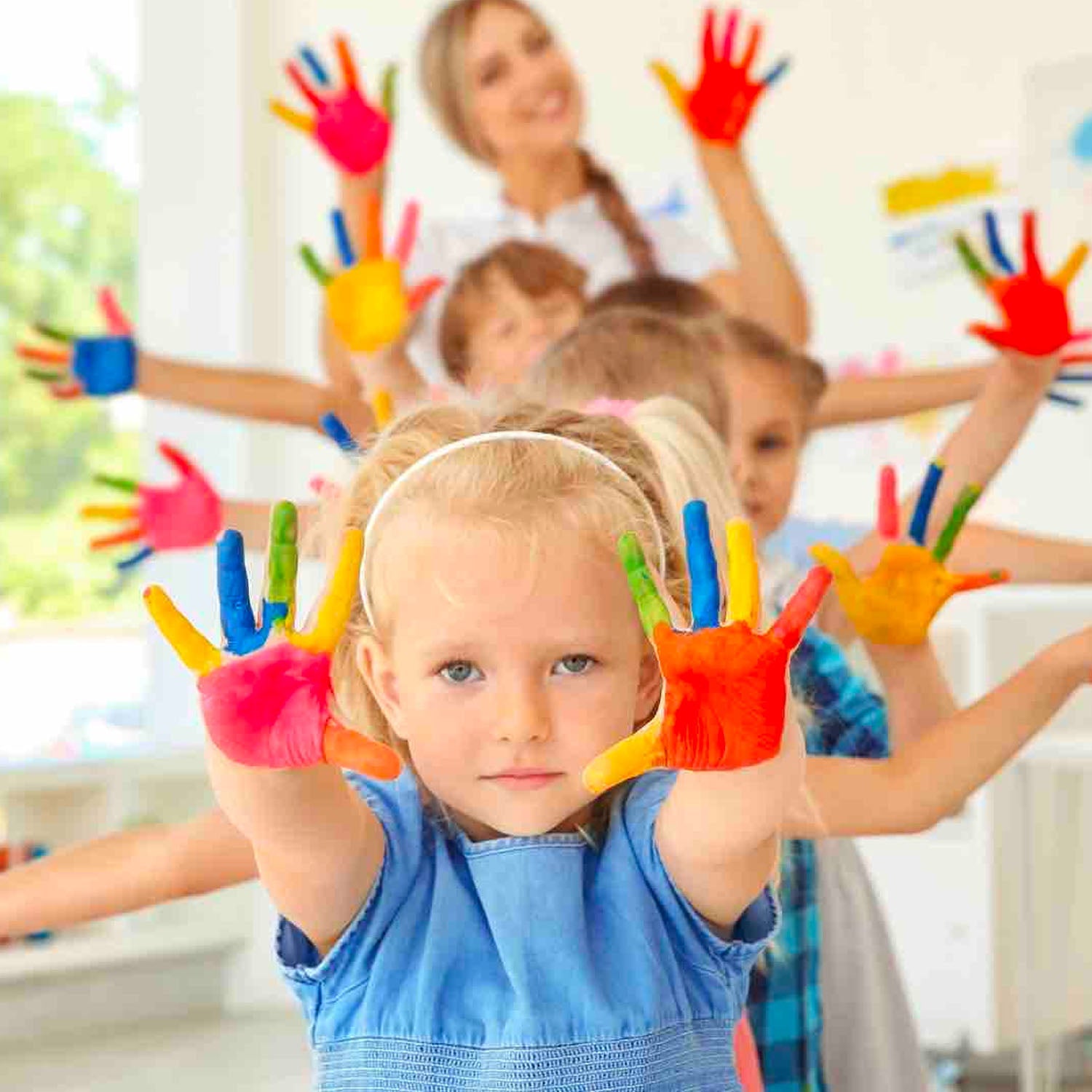Children in a classroom proudly display their painted hands, showcasing creativity and joy in their artistic activities.